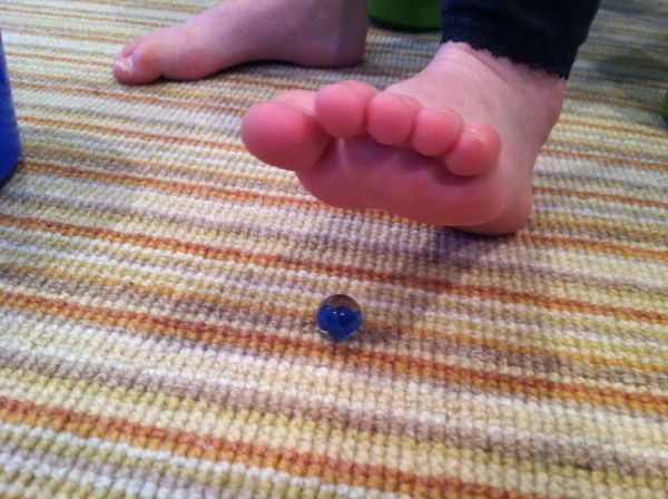 A kids feet and a marble