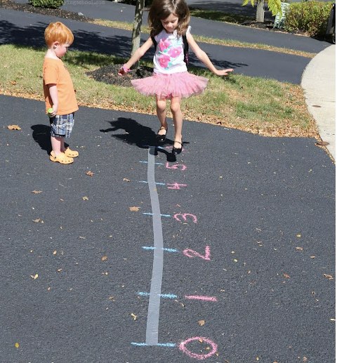 Parents and kids making a number line on the sidewalk