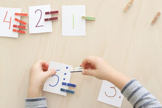 A child attaching clips to numbered chits of paper