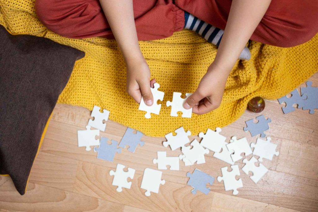 Kid solving jigsaw puzzle