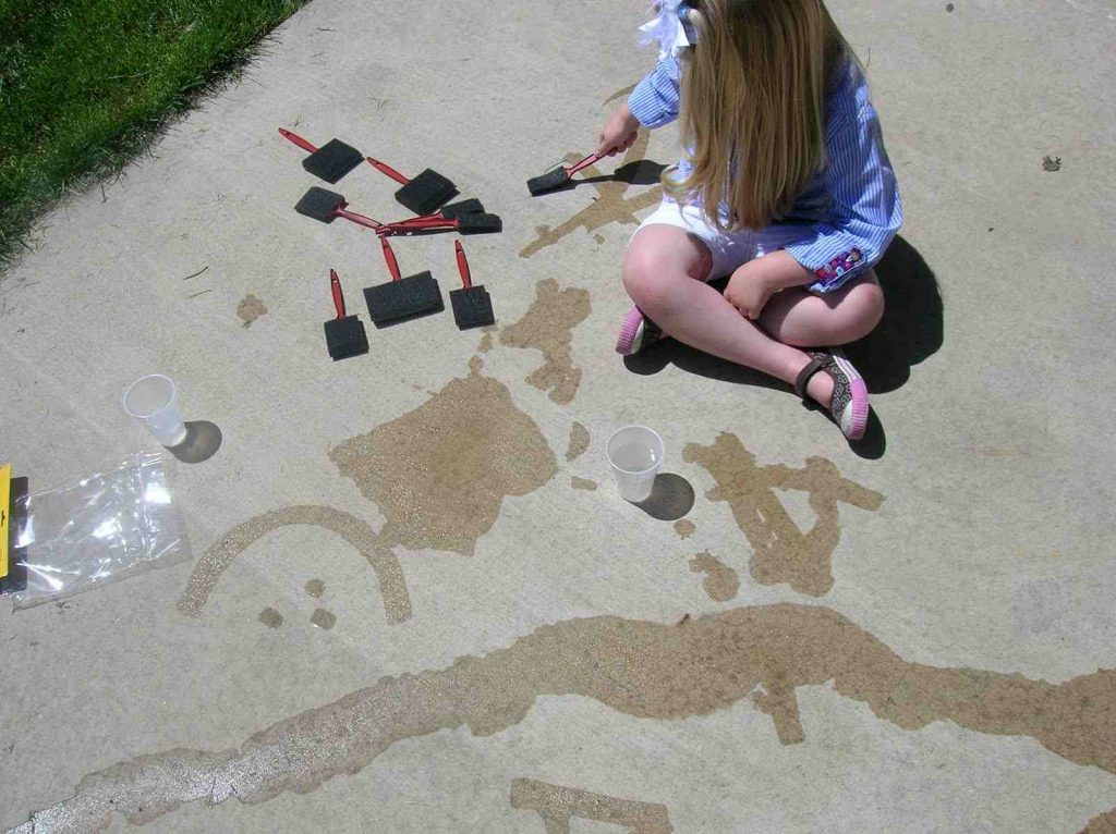 A girl writing with water on road