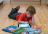Kid using an iPad lying on the floor
