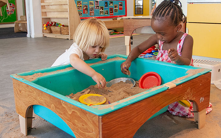 Two girls playing with sand