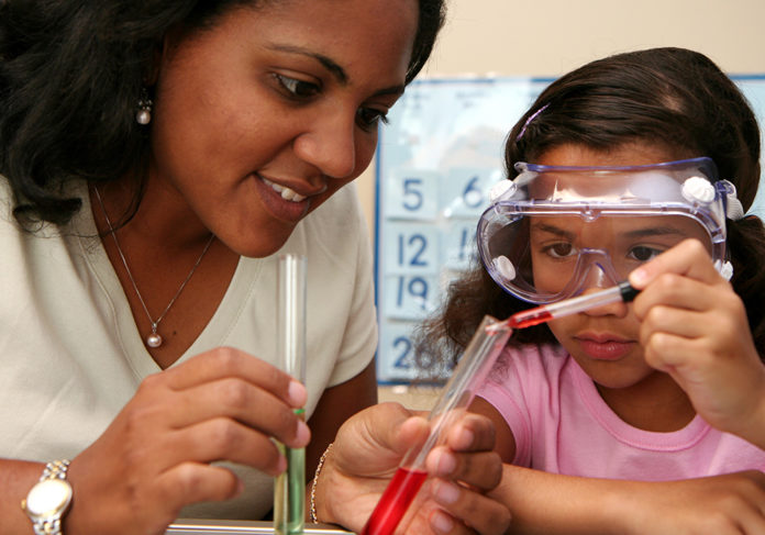 A kid doing experimenting with teacher