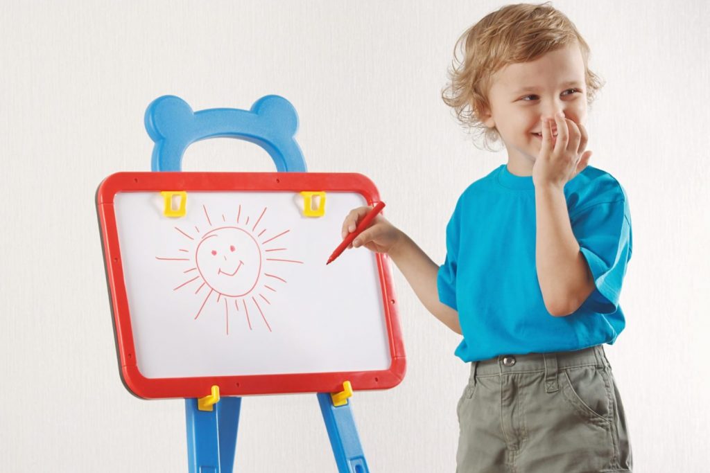 A kid drawing sun on a board
