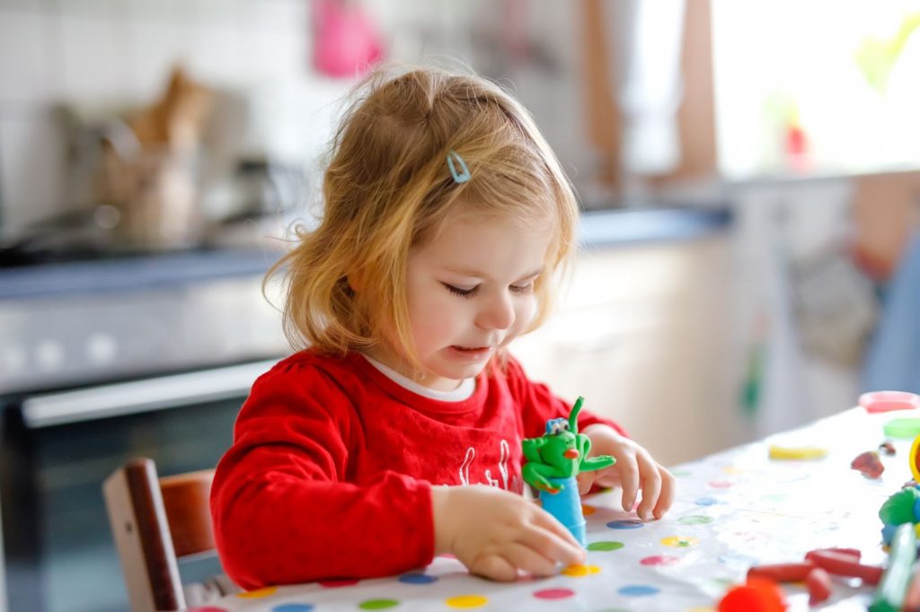 Toddler making fun creatures with playdough