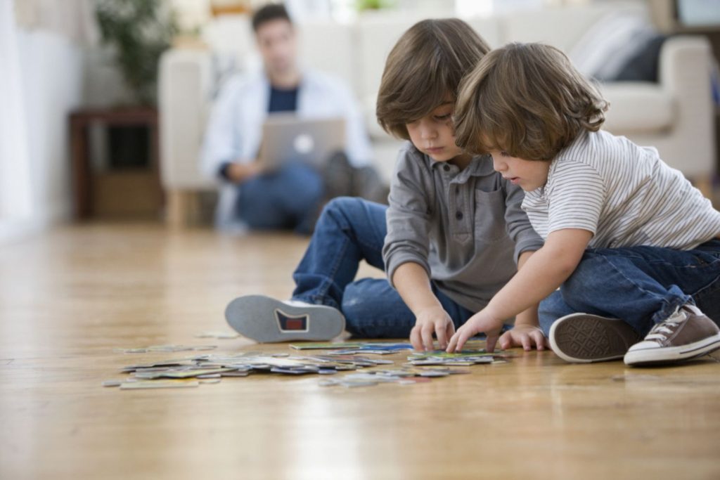 Brothers putting together the puzzles on floor