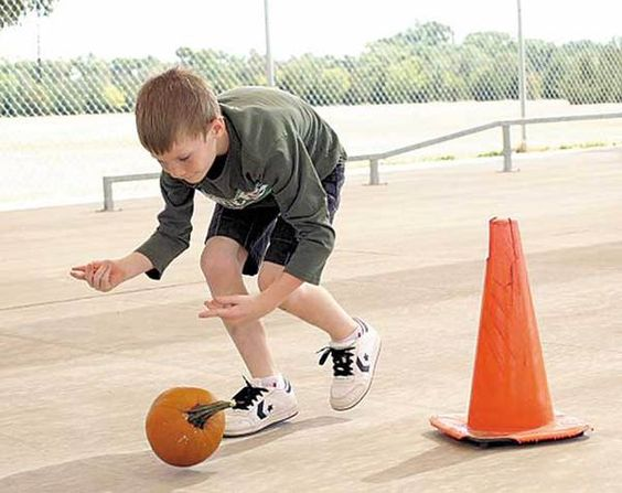 Children playing the game roll the pumpkin