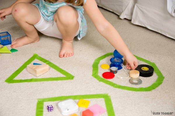 kid sorting various shapes into different categories