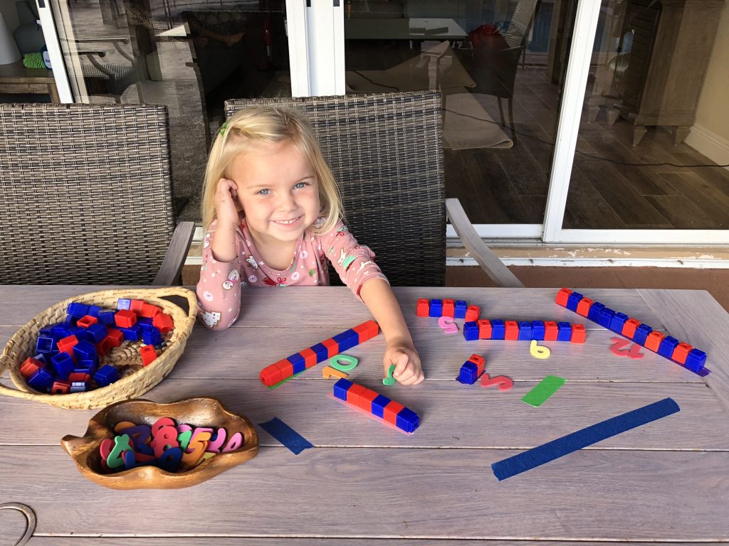 A kid using cubes to measure