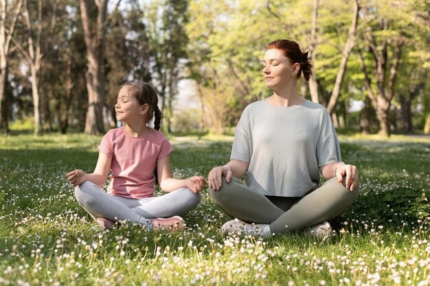 A girl doing breathing exercises with her mom