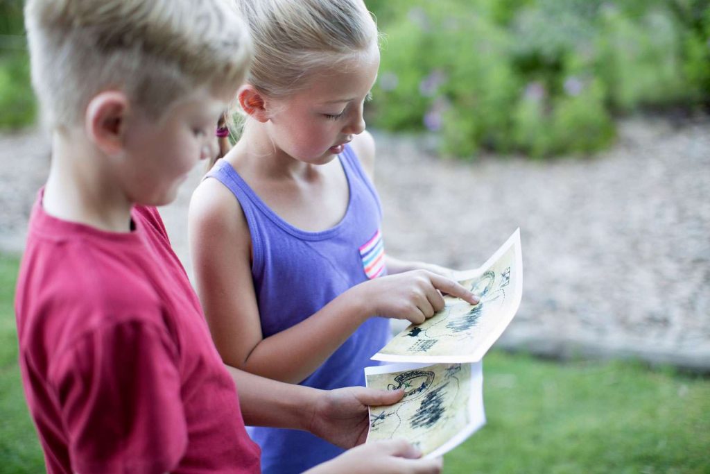 Two kids looking at a treasure hunt map