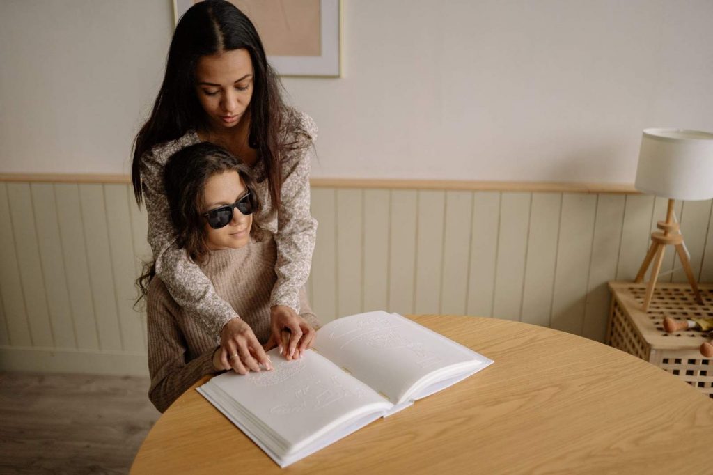 Person Helping a Woman in Using Braille