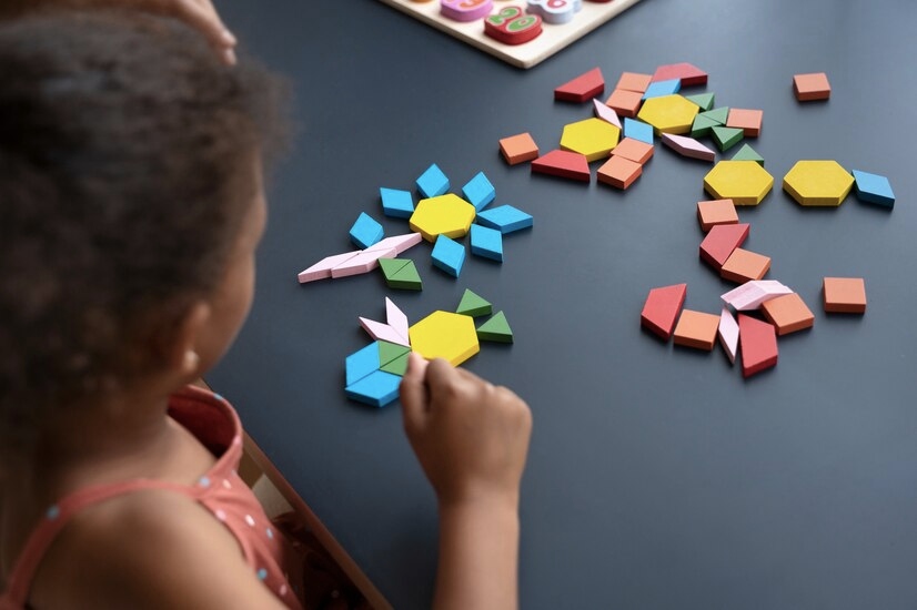 Kid using flats pieces of colorful tangrams