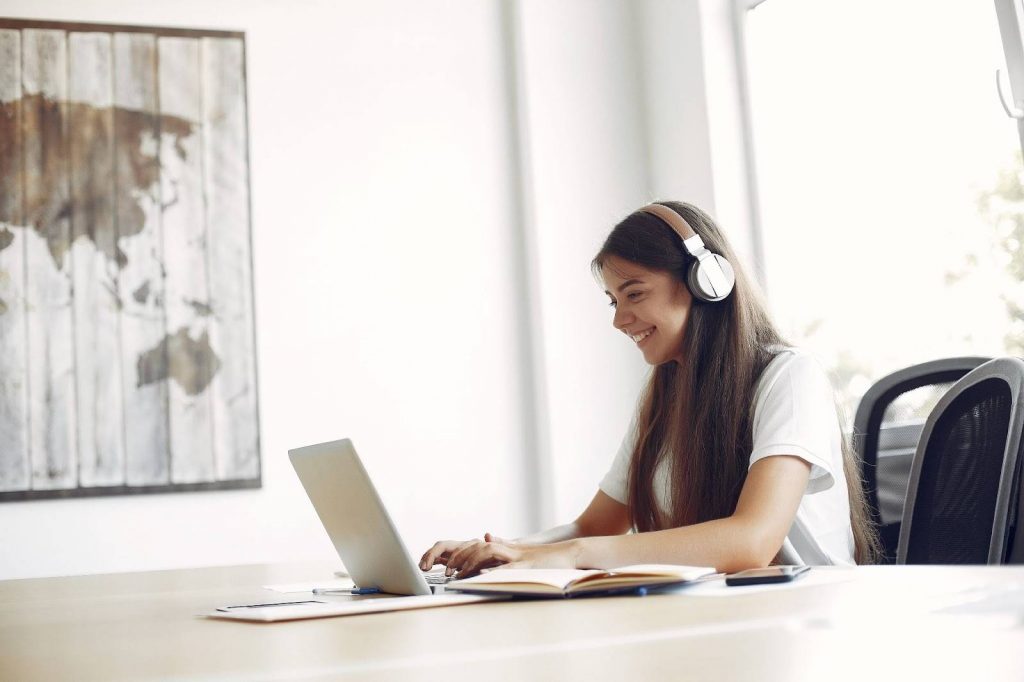 Young student sitting at the table and using the laptop