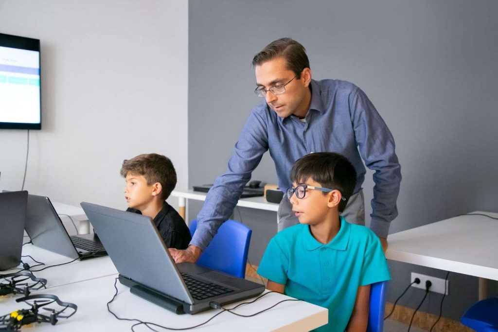 Teacher making a special child use assistive technology
