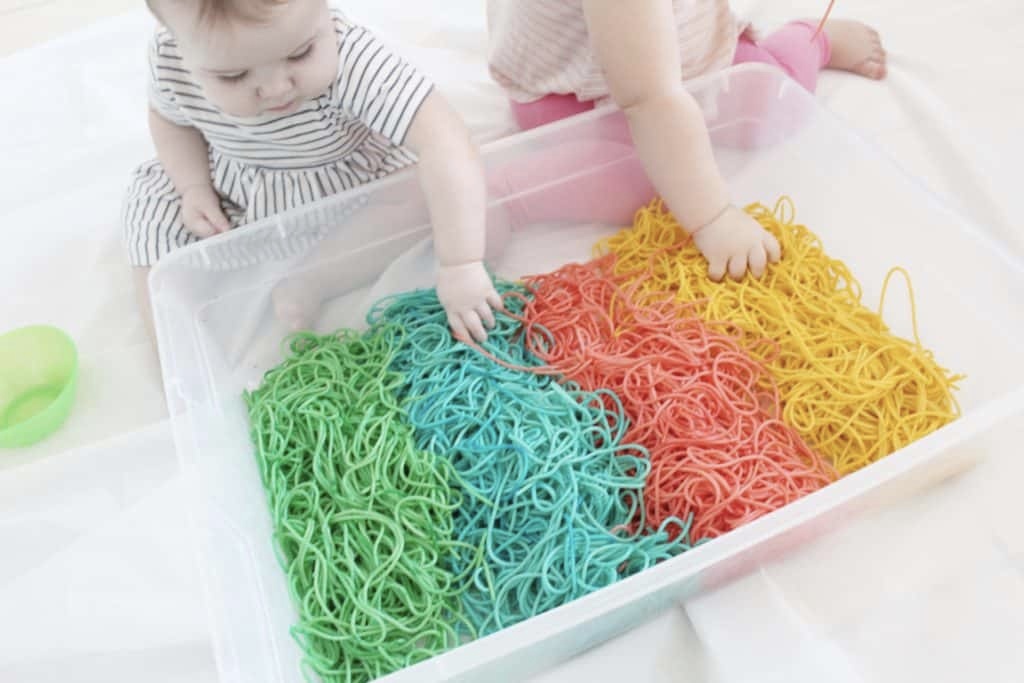 Kids playing with dyed spaghetti