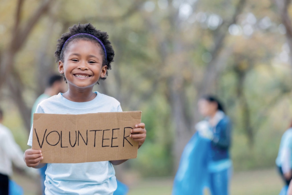 Kid holding a volunteer banner