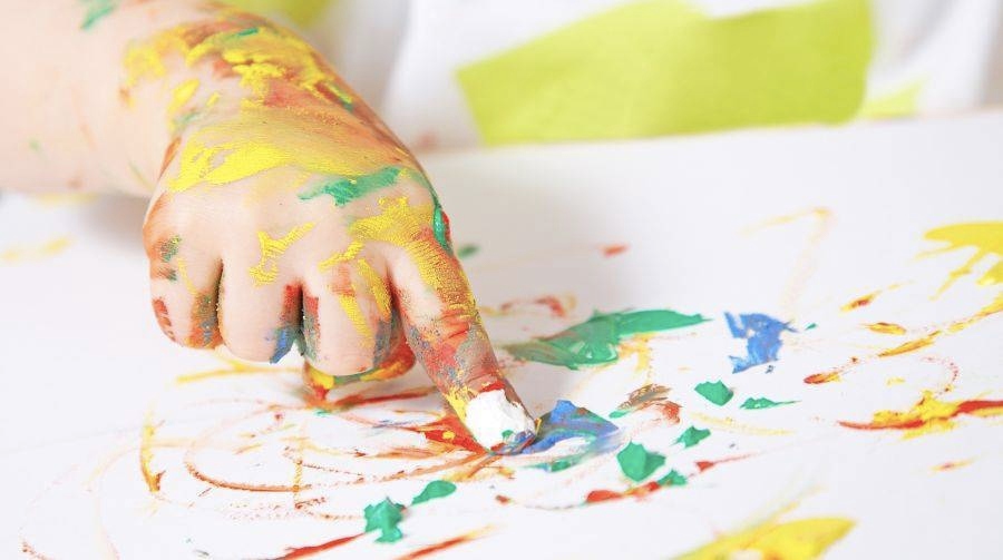 A kid doing finger painting