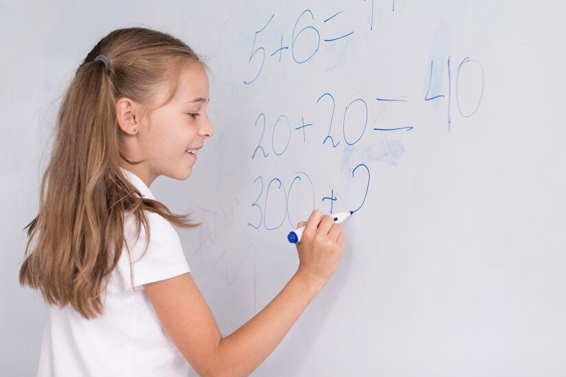 A girl doing math on whiteboard