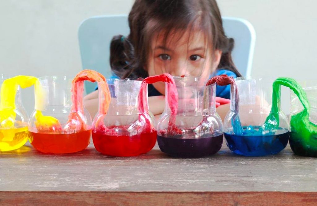 A kid doing a colorful science experiment