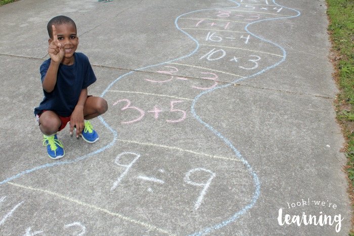 Kid drawing a sidewalk chalk math art