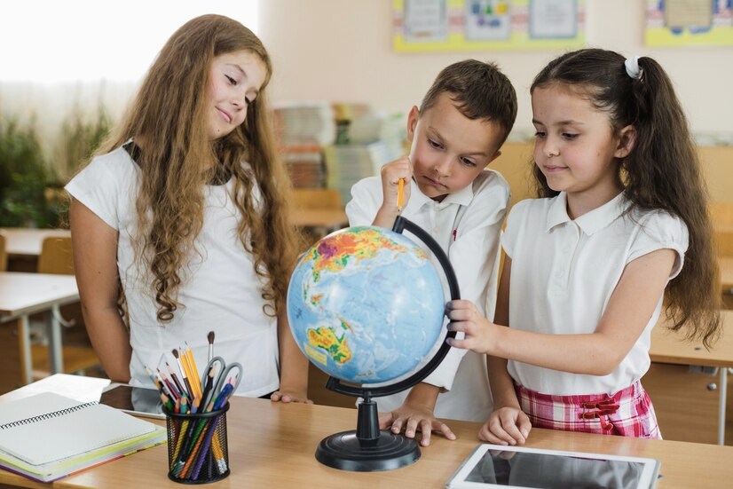 Children looking at globe standing on table