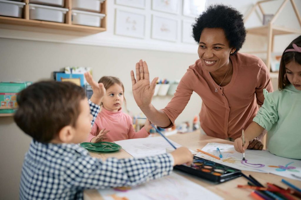 Teacher giving a hifive to kindergartener