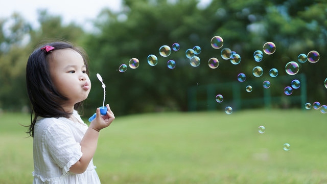 A kid blowing bubbles