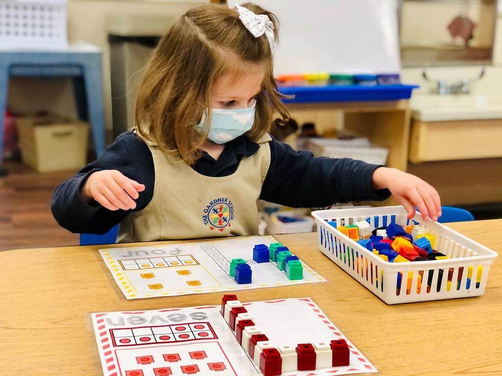 A kid using blocks to learn math