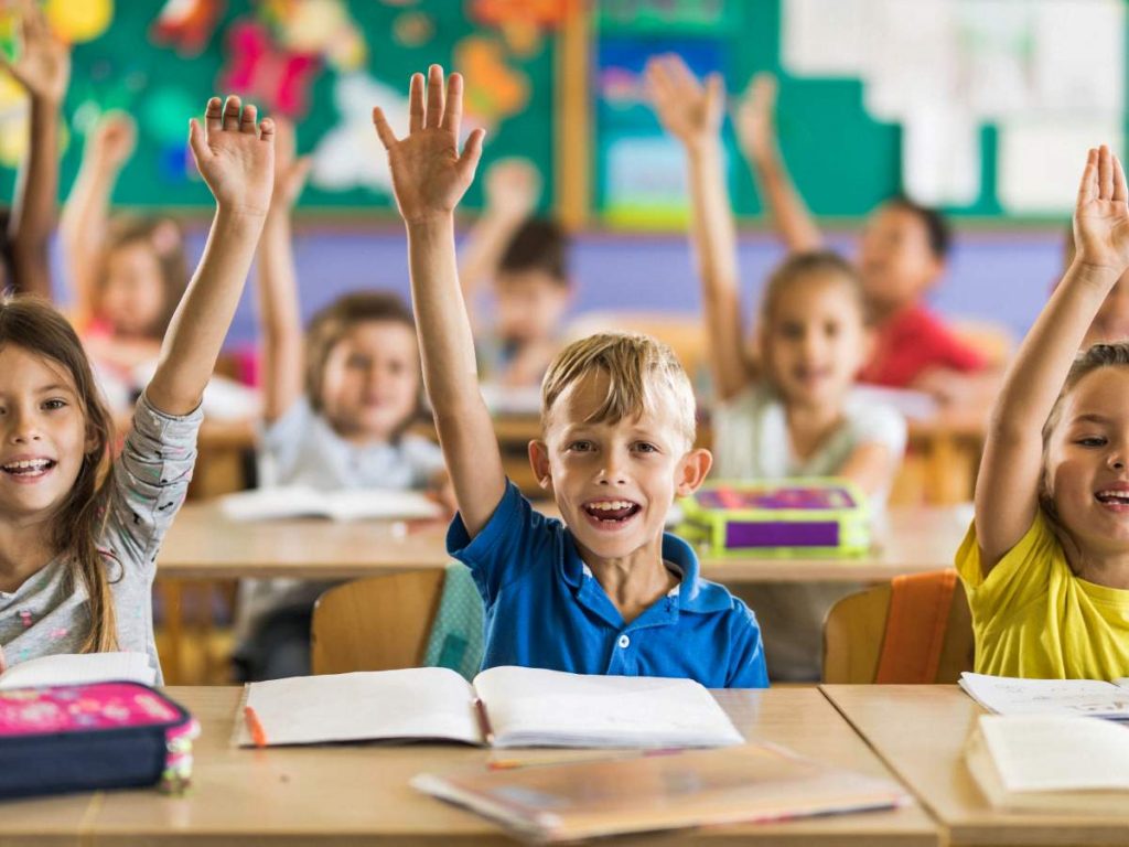 Kids raising hand in classroom