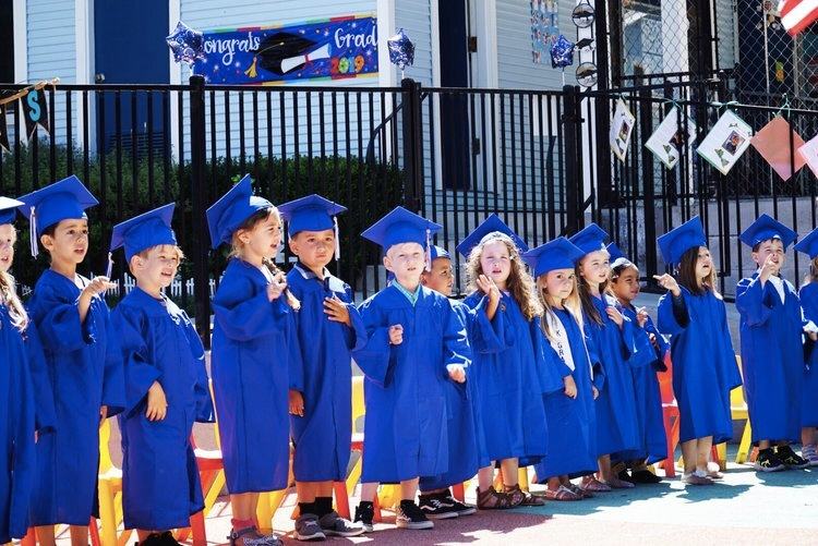 Kids standing in a line in graduation clothes