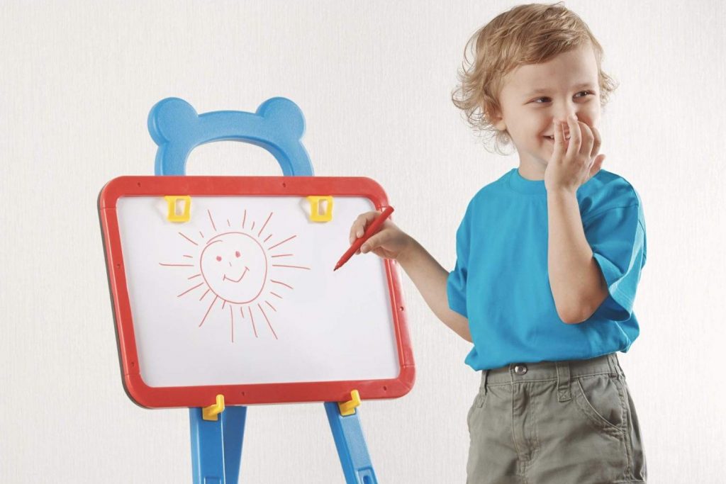 Kid drawing a sun on white board