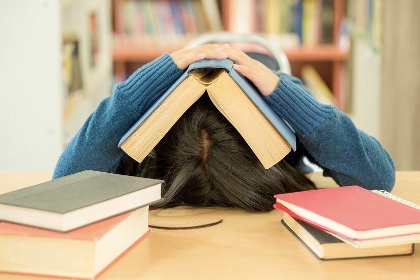 Student with open book reading it in library