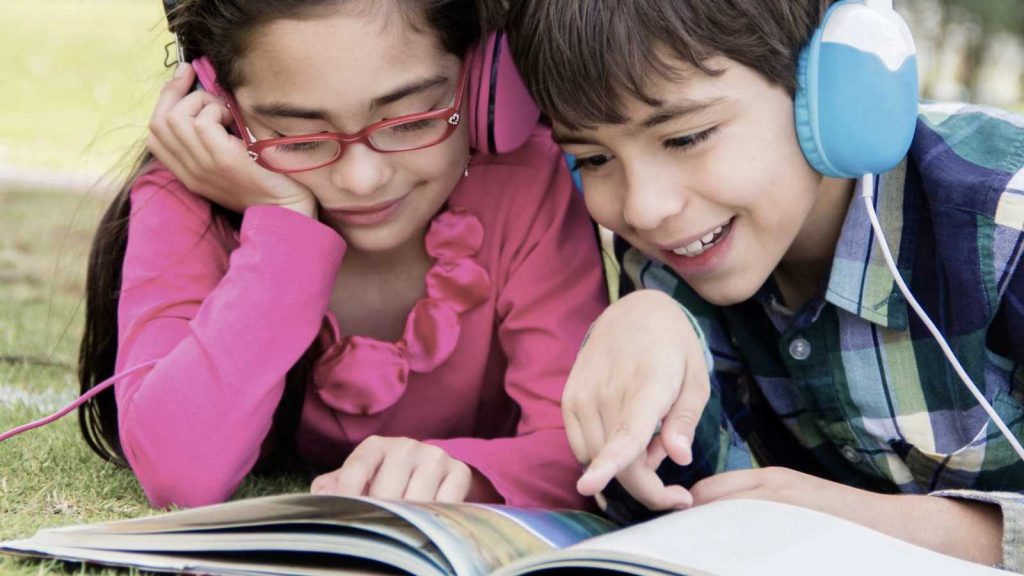 Two kids reading together using audiobooks