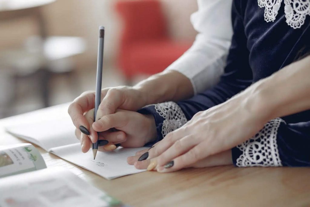 Parent guiding child how to write