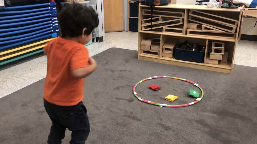 kid playing bean bag toss