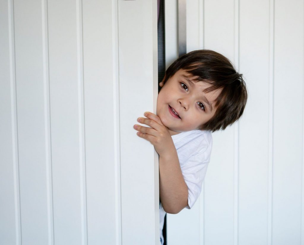 Kid hiding behind door